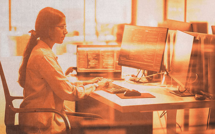 Woman in lab coat working at computer