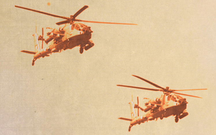 Two military helicopters flying in unison 