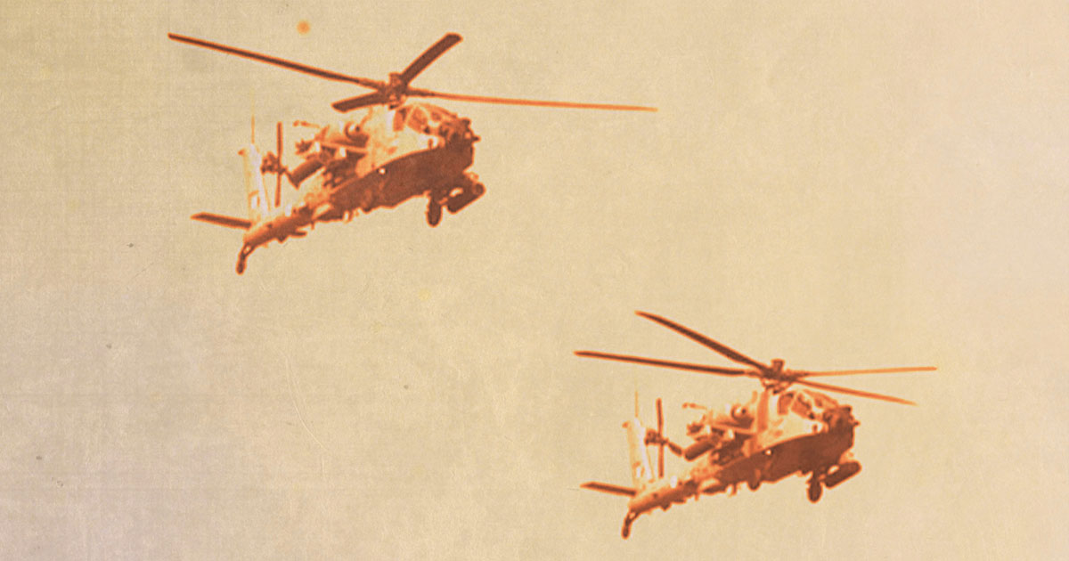 Two military helicopters flying in unison 