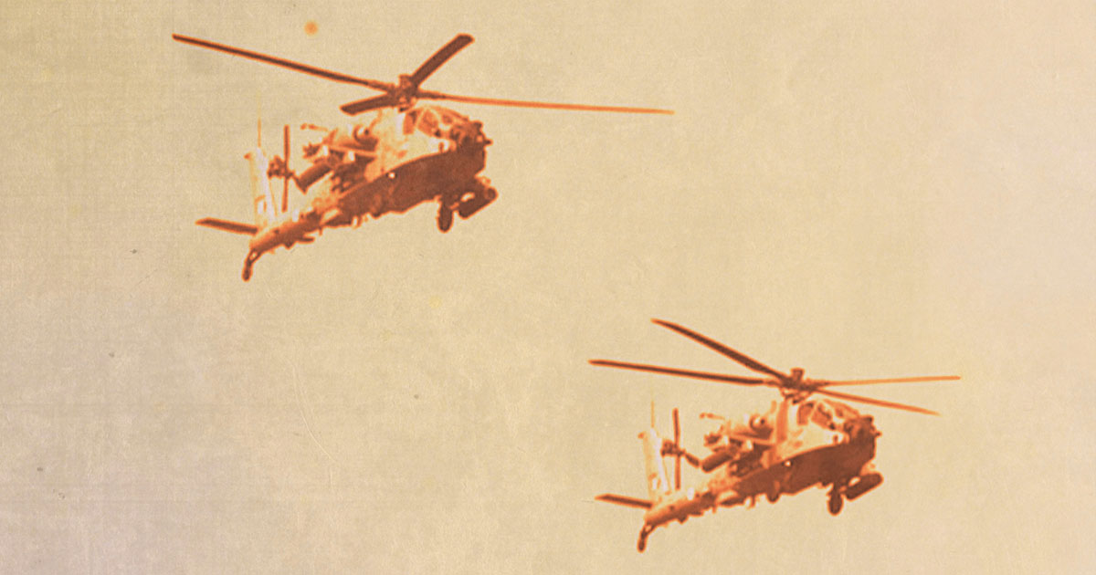 Two military helicopters flying in unison