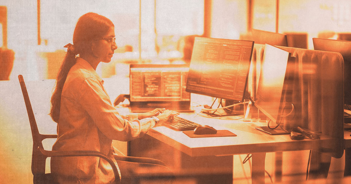 Woman in lab coat working at computer