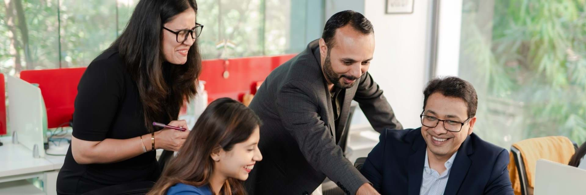 2 men and 2 women smiling at laptop